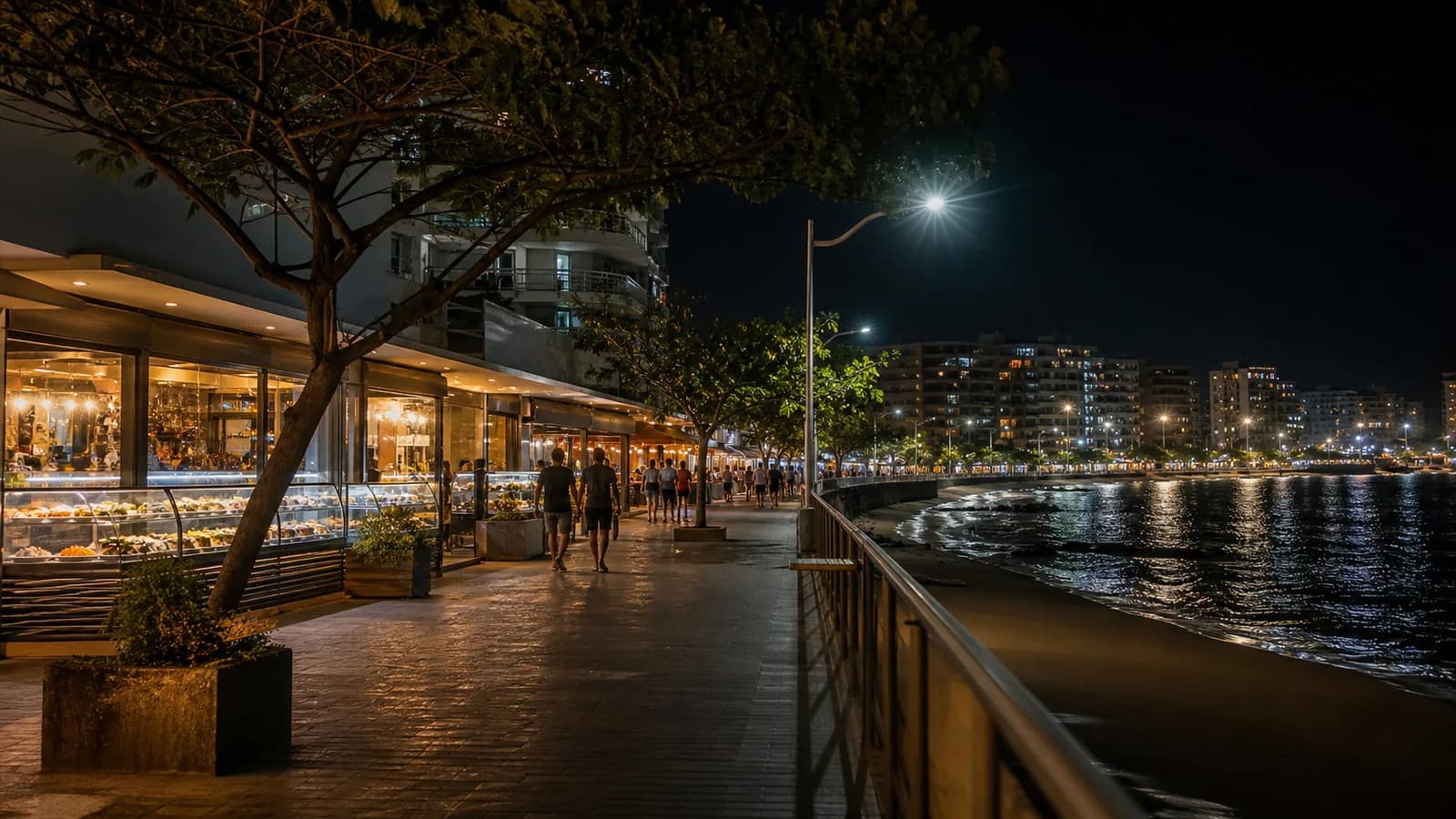 Rua de Guarapari a noite com vitrines de comida e movimento visto de longe
