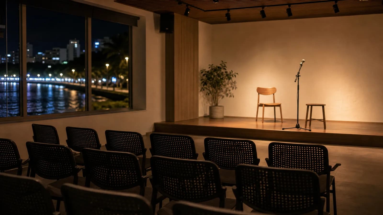 Ambiente cultural em Guarapari com cadeiras, luz quente e palco discreto sem pessoas identificaveis