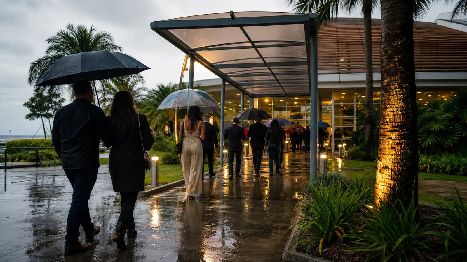 Entrada coberta de evento em Vila Velha com guarda-chuvas e piso molhado
